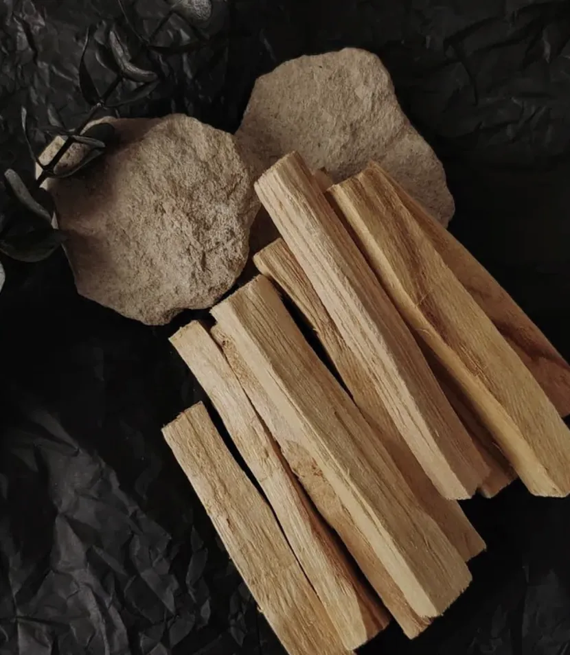 Split sticks of pale wood and smooth stones on a dark ground.